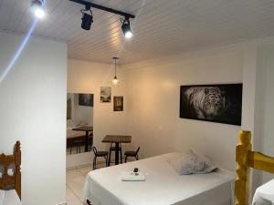 a bedroom with a bed and a table with chairs at Hotel Rota Dos Tropeiros in Castro