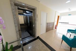 un corridoio con porta a vetri in un edificio di My Flat a Mogi das Cruzes
