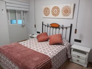 um quarto com uma cama com um edredão vermelho em Apartamento de la Haya, junto al Teatro Romano em Mérida