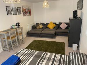 een woonkamer met een bank en een tafel bij Very large double room with corner sofa and Sky TV in Newhaven