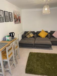 een woonkamer met een bank en een tafel bij Very large double room with corner sofa and Sky TV in Newhaven