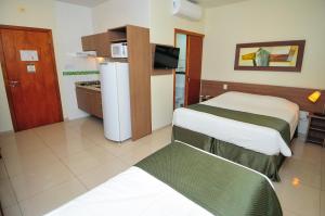 a hotel room with two beds and a refrigerator at My Flat in Mogi das Cruzes +27 photos
