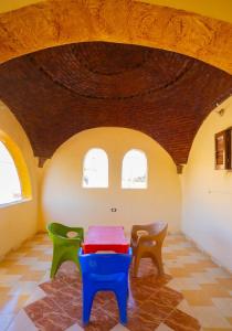 a table and chairs in a room with a ceiling at Desert Escape siwa -with palm & olive Garden - Hot Spring in Siwa