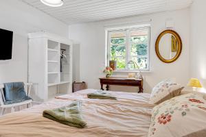 a bedroom with a bed and a desk and a window at Skortskær Bondegårdsferie in Havnsø