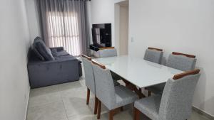 uma sala de jantar com uma mesa branca e cadeiras em Apartamento em itanhaem em Itanhaém