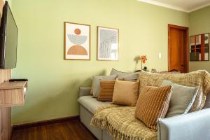 a living room with a couch with pillows on it at Charmoso Apartamento no Centrinho de Capivari in Campos do Jordão