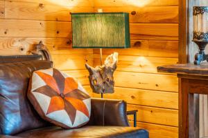 een woonkamer met een leren bank en een lamp bij Misty Mountain Cabin Spectacular Scenic Escape by Caddo River in Glenwood