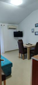 a room with a table and chairs and a tv at Sea and Sunshine in Tivat