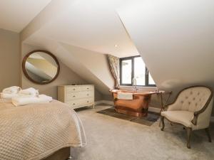 um quarto com uma cama, um lavatório e um espelho em Tarn End Cottages 12 em Brampton
