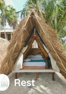 ein eingebettetes Zelt am Strand mit Palmen in der Unterkunft Glamping Asana Bacalar in Bacalar