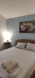 a white bed with two towels on top of it at Sea and Sunshine 100m to beach,free parking,centar,View in Tivat