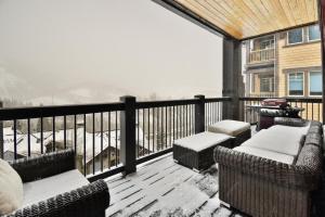 a balcony with couches and chairs on a deck with snow at Flagstaff #301 in Park City