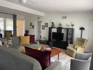 a living room with a couch and a tv at Heated pool home only 2.3miles from the beach in St. Petersburg
