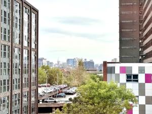 a view of a parking lot between two tall buildings at Luxury 1 Bedroom Apartment in Old Trafford in Manchester