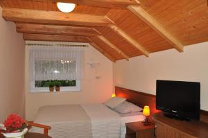 a bedroom with a bed and a flat screen tv at Central Łeba Suites in Łeba