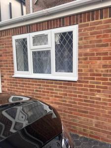a brick building with a window and a car in front at Cosy and warm studio apartment in Bexleyheath in Belvedere