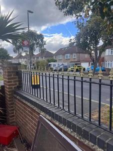 a black fence next to a street with houses at Cosy and warm studio apartment in Bexleyheath in Belvedere