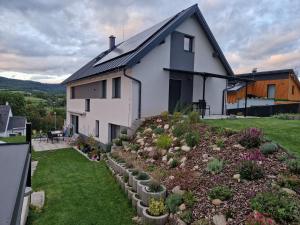una casa blanca con un jardín delante en Apartmán Anamo, en Vrchlabí
