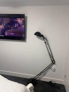 a black lamp sitting next to a wall with a tv at Cosy and warm studio apartment in Bexleyheath in Belvedere