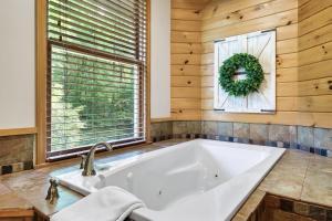 baño con bañera blanca y ventana en Autumn Lane, en Gatlinburg