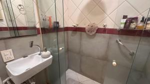 een badkamer met een wastafel en een glazen douchecabine bij Praia de Ipanema in Rio de Janeiro