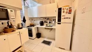 een keuken met witte kasten en een koelkast bij Praia de Ipanema in Rio de Janeiro +11 foto's