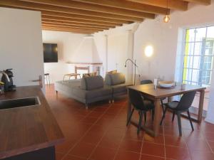 cocina y sala de estar con mesa y sofá en Villa Cedros, en Santa Cruz das Flores