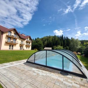 een glazen paviljoen op een terras voor een huis bij Tylicki Zdrój in Tylicz