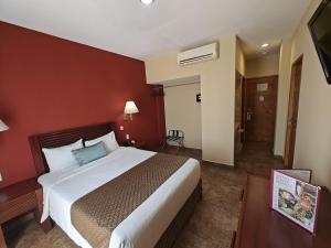 1 dormitorio con 1 cama grande en una pared roja en Seven Crown La Paz Centro Historico, en La Paz