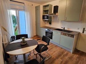 a kitchen with a table and chairs and a kitchen with a window at FeWo Gabriella in Püttlingen