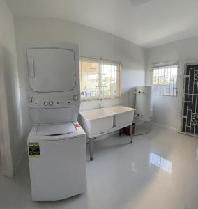 a white bathroom with a tv and a sink at Villa Di-Nae in The Rock