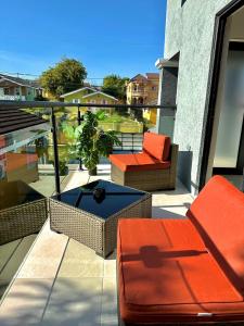 un patio con 2 sillas y una mesa en el balcón en Villa Di-Nae, en The Rock