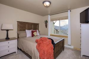a bedroom with a large bed and a window at Deer Run Condo - 12 Blacktail Buck in Big Sky