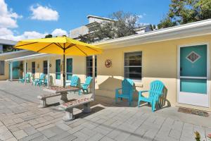 une terrasse avec une table, des chaises et un parasol dans l'établissement Pelican Beach Studio #6, à Clearwater Beach