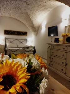 1 dormitorio con 1 cama con un ramo de flores en Dimora Nonna Martina, en Martina Franca