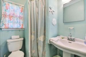 La salle de bains est pourvue de toilettes, d'un lavabo et d'un miroir. dans l'établissement Pelican Beach Studio #6, à Clearwater Beach