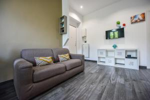 sala de estar con sofá marrón y suelo de madera en Benvenuti Casa Leo - Elegante Appartamento, en Turín
