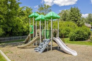 a playground with slides and umbrellas in a park at Furnished Garden Style Apt, Pool Gym Parking Pb in Newark