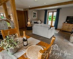 a living room with a table with a bottle of wine at Dusty Clough Barn in Preston
