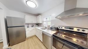 a kitchen with white cabinets and a stainless steel refrigerator at Furnished 2br Pool Gym Parking Pb in Newark