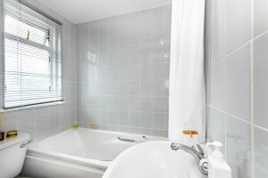 Spacious en-suite in a 5-Bedroom House at Hanwell (2nd Floor) في Hanwell: حمام مع حوض ومرحاض ومغسلة