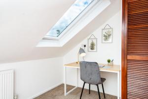 an attic office with a desk and a skylight at Spacious en-suite in a 5-Bedroom House at Hanwell (2nd Floor) in Hanwell