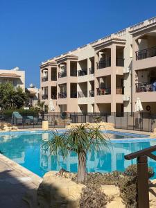 een zwembad voor een groot appartementencomplex bij Royal Seacrest Residence in Paphos City