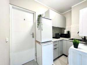 a kitchen with white cabinets and a refrigerator at MMRent Bubble Room in Gdańsk