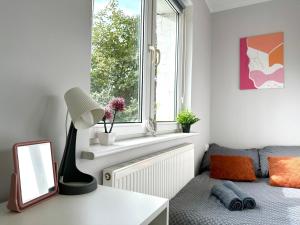 a living room with a window and a desk with a mirror at MMRent Mary's Room in Gdańsk