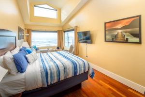 Un dormitorio con una cama grande y una ventana en Three Arch Inn, en Oceanside