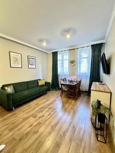 a living room with a green couch and a table at Starovka Apartament in Elblag