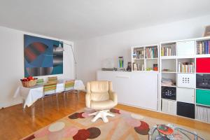 Apartment near Pigalle in Paris - Welkeys في باريس: غرفة معيشة مع كرسي ومكتب