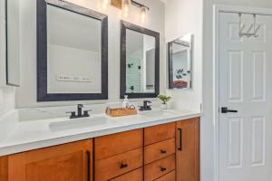 a bathroom with two sinks and two mirrors at Sunny Arizona Getaway Your Home Under theDesertSun in Mesa