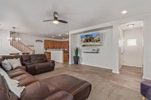 a living room with a brown couch and a kitchen at Sunny Arizona Getaway Your Home Under theDesertSun in Mesa